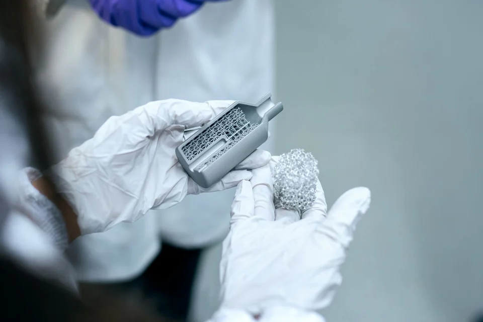 Gloved hands holding a small sample in a laboratory