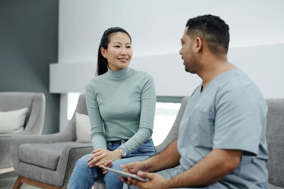 A clinician talking with a patient while holding a tablet