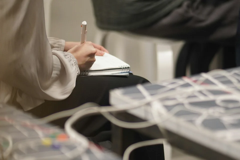 A person taking handwritten notes while seated at an event